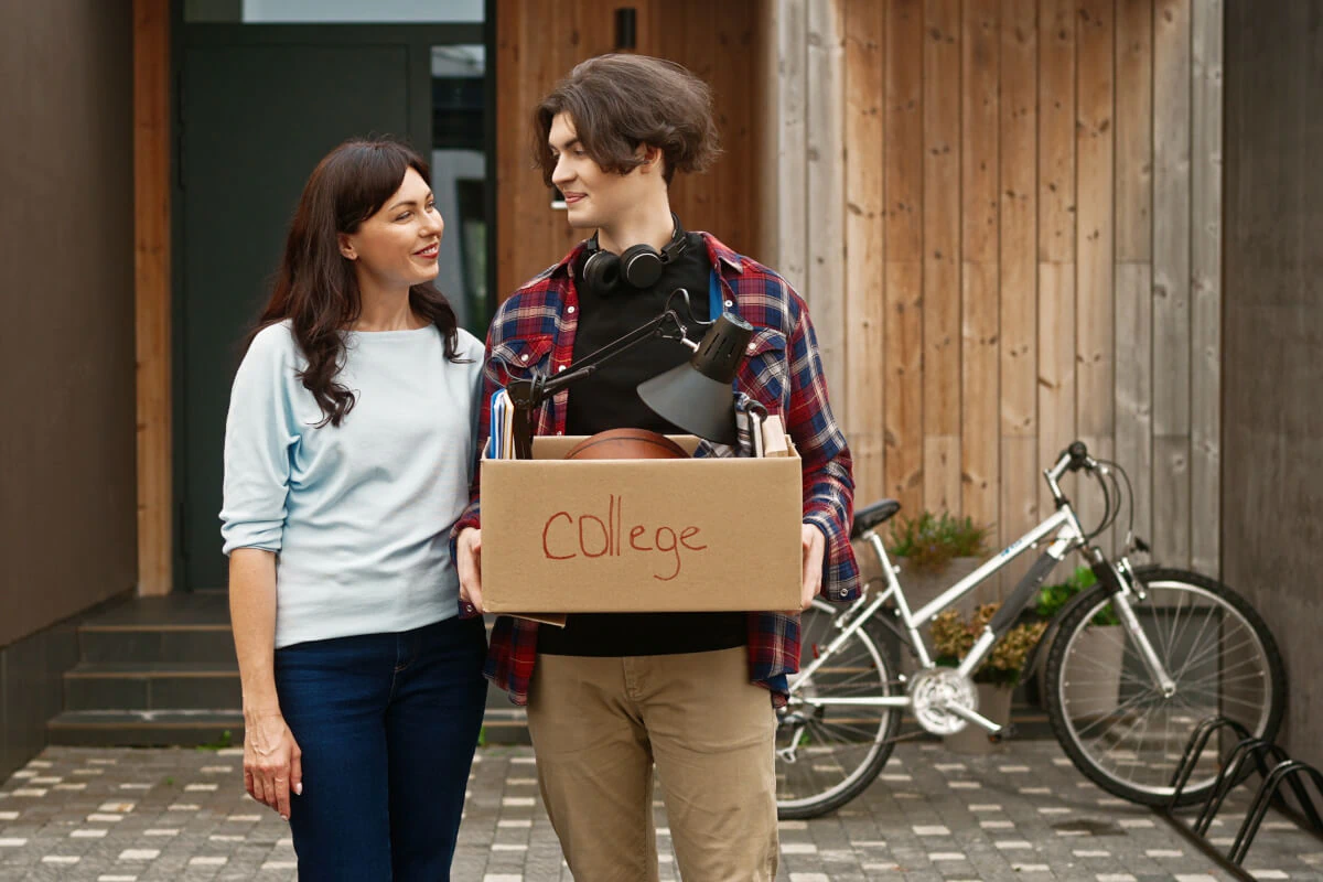 Mother and son carrying box of belongings during move-out.